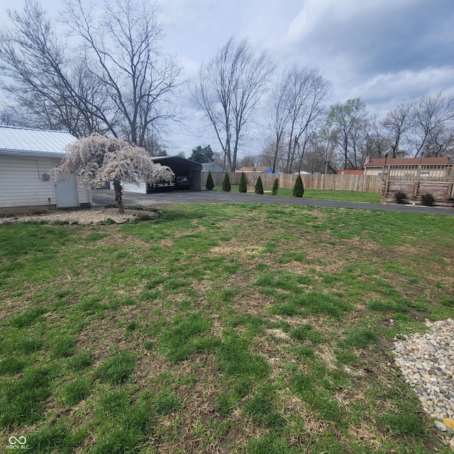 1024 Foltz St, Indianapolis, IN 46241 - view of yard featuring a carport, aphalt driveway, and fence