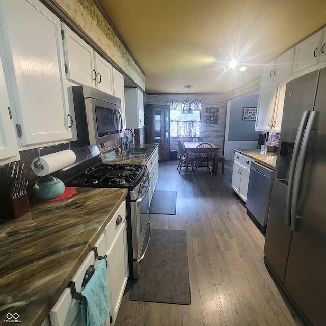 1024 Foltz St, Indianapolis, IN 46241 - kitchen featuring white cabinetry, hardwood / wood-style floors, a chandelier, a sink, and appliances with stainless steel finishes