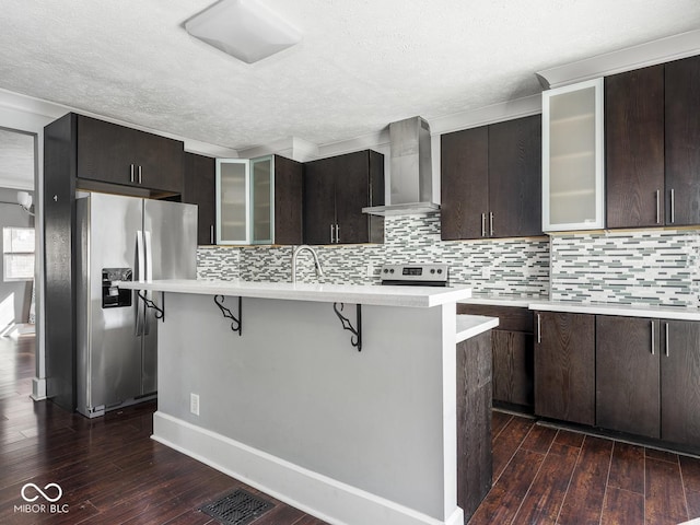317 E 37th St, Indianapolis, IN 46205 - kitchen featuring light countertops, wall chimney range hood, a breakfast bar area, and appliances with stainless steel finishes