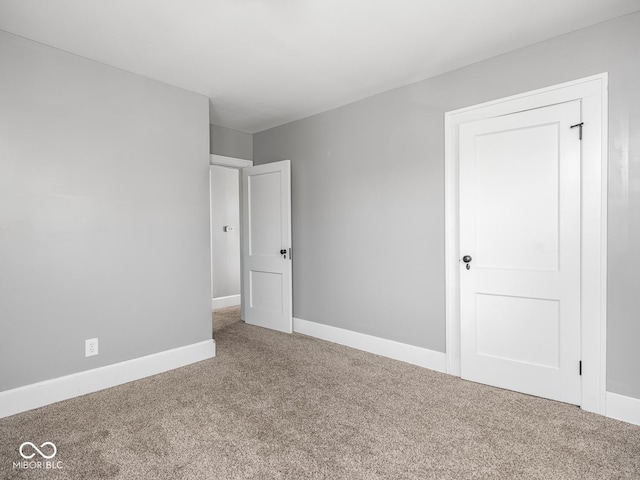 317 E 37th St, Indianapolis, IN 46205 - unfurnished bedroom with baseboards and carpet flooring