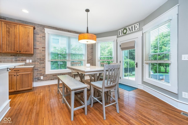 2353 Woodcreek Crossing Blvd, Avon, IN 46123 - dining room featuring light wood-type flooring, healthy amount of natural light, baseboards, and brick wall