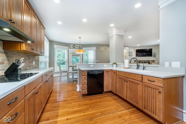 2353 Woodcreek Crossing Blvd, Avon, IN 46123 - kitchen featuring black appliances, light wood-style flooring, under cabinet range hood, light countertops, and backsplash