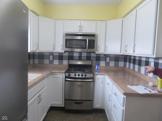 kitchen featuring white cabinets, light countertops, appliances with stainless steel finishes, and tasteful backsplash