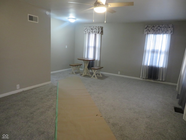 unfurnished room featuring visible vents, carpet, and plenty of natural light