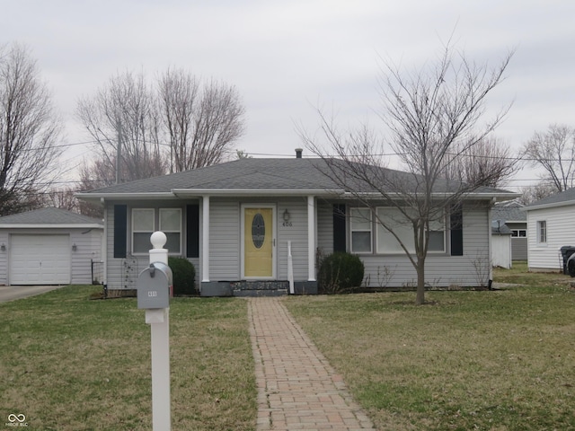 view of front of home with a detached garage, an outbuilding, a shingled roof, and a front lawn