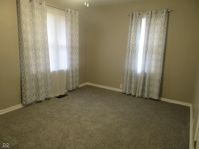 carpeted empty room featuring baseboards and ceiling fan