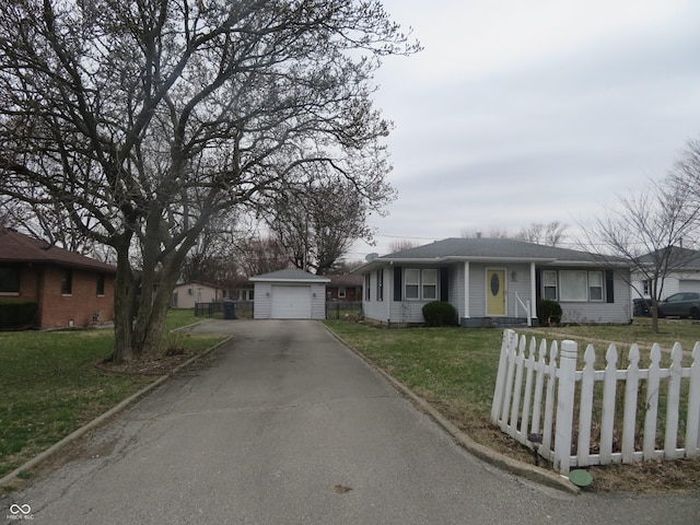 ranch-style home with an outbuilding, fence, aphalt driveway, a front yard, and a garage