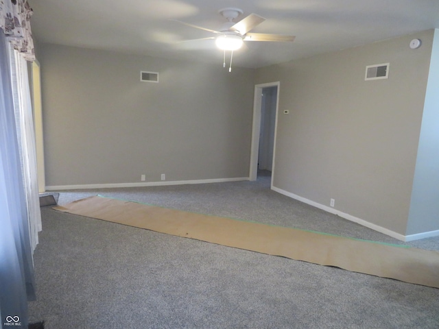 empty room with baseboards, carpet floors, visible vents, and a ceiling fan