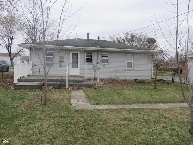 view of front of house with a front yard, a wooden deck, and fence