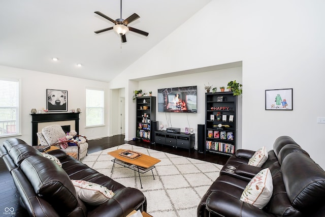 living room featuring high vaulted ceiling, ceiling fan, baseboards, and wood finished floors