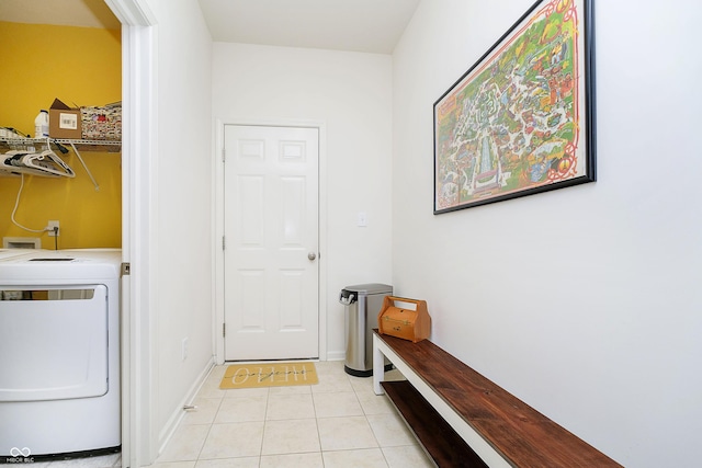 laundry area with baseboards, laundry area, washer / clothes dryer, and light tile patterned flooring