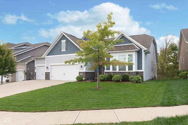 craftsman inspired home with concrete driveway, a front yard, an attached garage, and stone siding