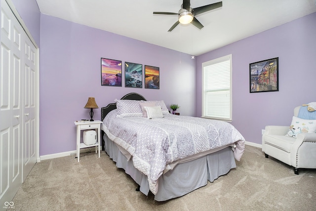 bedroom with baseboards, light carpet, ceiling fan, and a closet