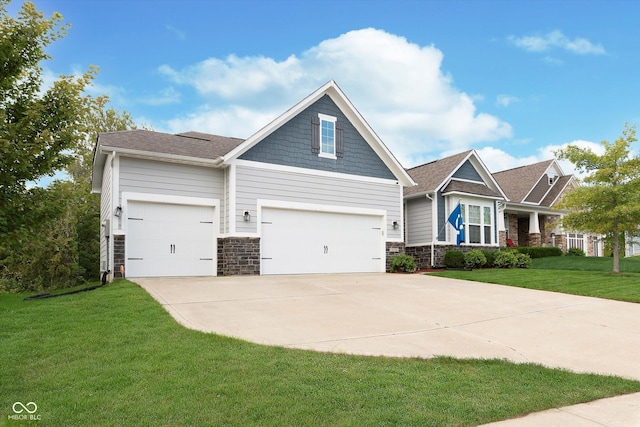 craftsman inspired home featuring a garage, a front yard, driveway, and stone siding