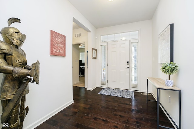 foyer featuring baseboards, hardwood / wood-style flooring, and visible vents