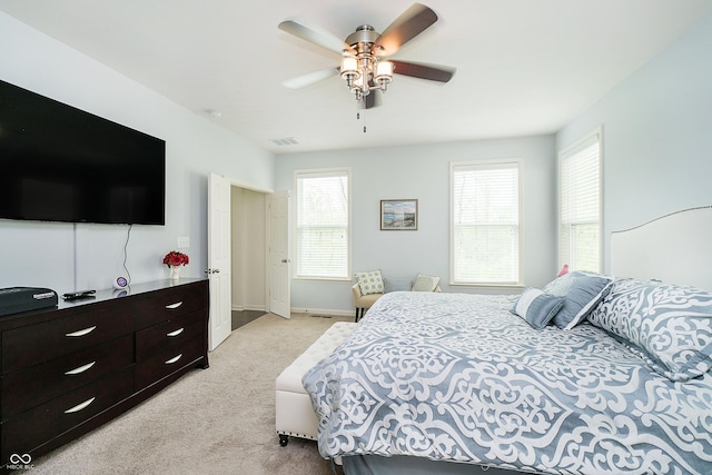 bedroom featuring visible vents, baseboards, ceiling fan, and light carpet