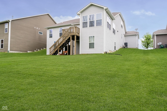 rear view of house with stairs, a lawn, and a wooden deck