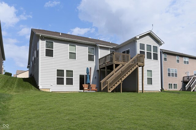 rear view of house featuring a wooden deck, stairs, and a lawn