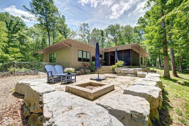 7493 E Rush Ridge Rd, Bloomington, IN 47401 - back of property with a sunroom, a chimney, and a patio