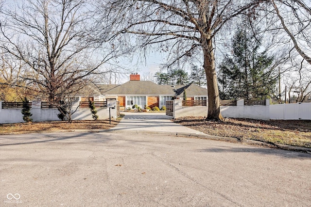 1227 S Pickwick Pt, Bloomington, IN 47401 - ranch-style home featuring driveway, a fenced front yard, and a chimney