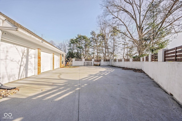 1227 S Pickwick Pt, Bloomington, IN 47401 - view of patio featuring driveway, a garage, and fence