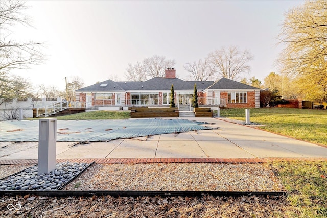 1227 S Pickwick Pt, Bloomington, IN 47401 - back of property with a chimney, a covered pool, a deck, and a yard