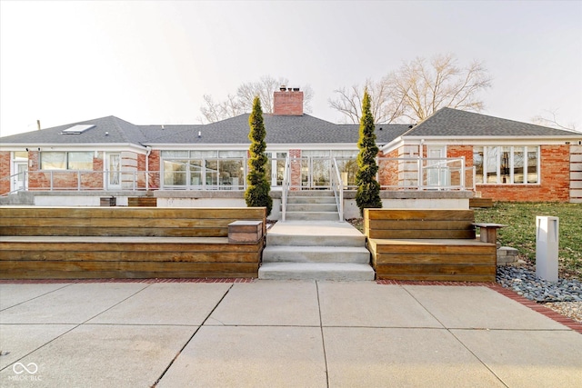 1227 S Pickwick Pt, Bloomington, IN 47401 - back of house with brick siding, a shingled roof, and a chimney