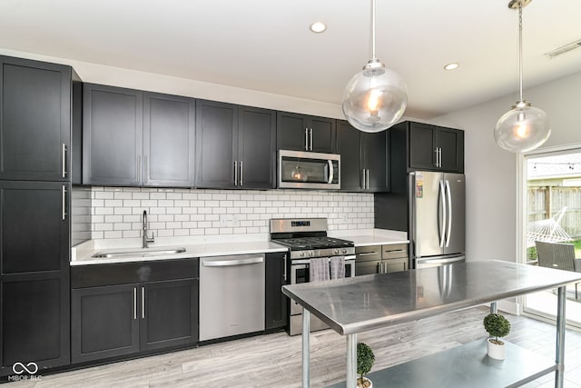 kitchen with a sink, light countertops, stainless steel appliances, and visible vents