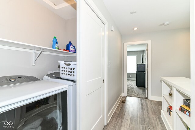 clothes washing area featuring washer and dryer, laundry area, light wood-style flooring, recessed lighting, and baseboards