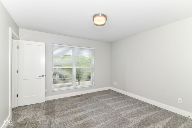 carpeted spare room with baseboards and visible vents