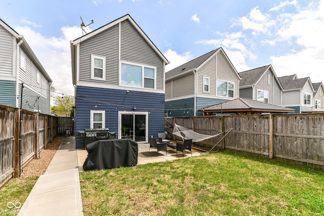 rear view of property featuring a yard, a fenced backyard, a patio area, and an outdoor hangout area