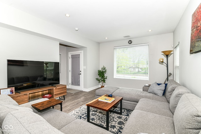 living room featuring recessed lighting, baseboards, and wood finished floors