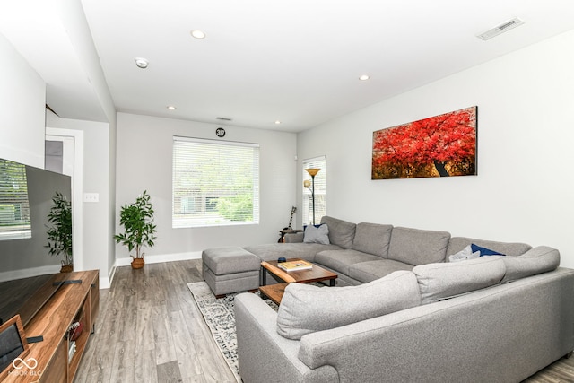 living room featuring recessed lighting, light wood finished floors, a healthy amount of sunlight, and visible vents