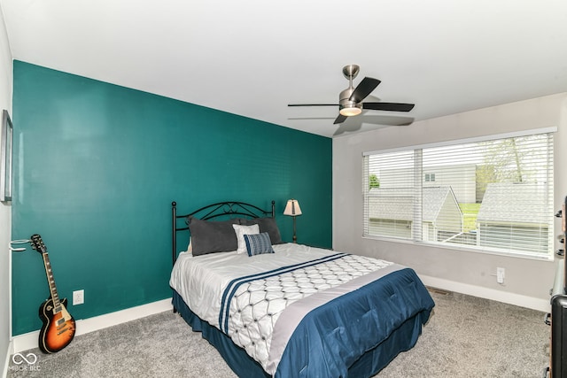 bedroom featuring carpet floors, a ceiling fan, baseboards, and an accent wall