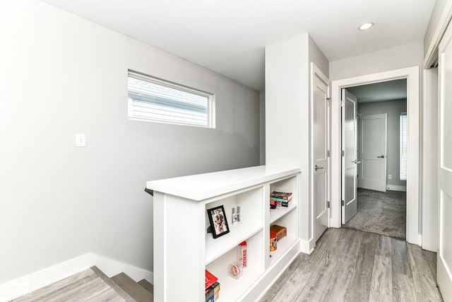 hallway featuring baseboards, recessed lighting, and light wood-style flooring