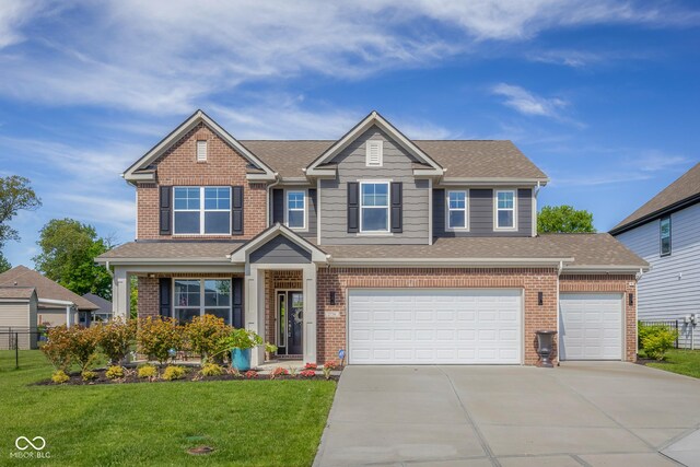 2736 Victory Dr, Columbus, IN 47203 - view of front facade featuring driveway, brick siding, a shingled roof, and a garage