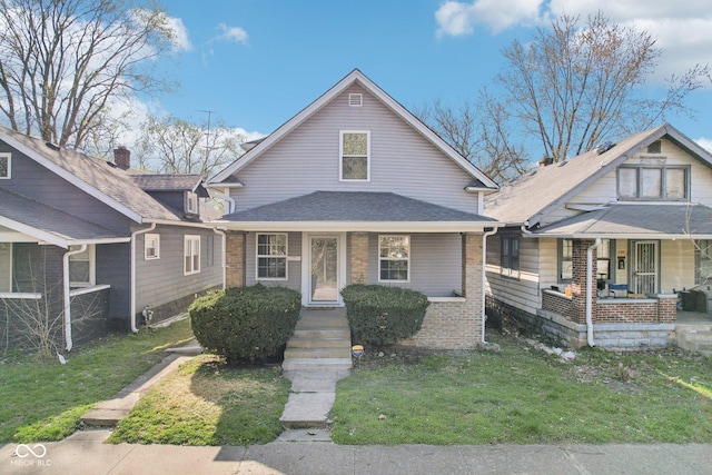 422 N Oxford St, Indianapolis, IN 46201 - bungalow-style home with covered porch, a front lawn, roof with shingles, and brick siding