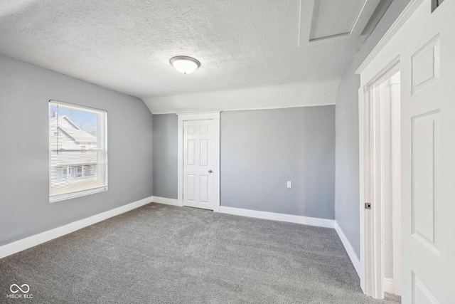 422 N Oxford St, Indianapolis, IN 46201 - unfurnished bedroom featuring carpet flooring, baseboards, vaulted ceiling, a textured ceiling, and a closet