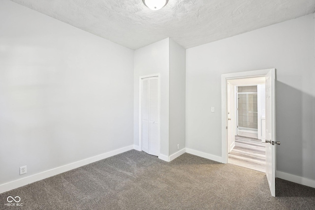 422 N Oxford St, Indianapolis, IN 46201 - unfurnished bedroom featuring carpet, baseboards, a closet, and a textured ceiling
