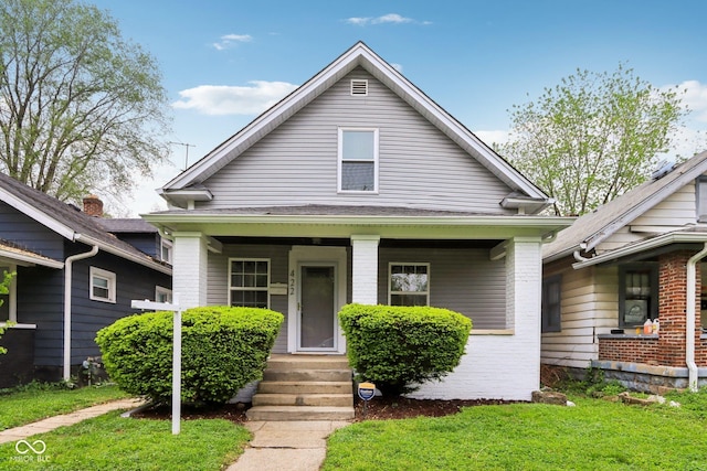 422 N Oxford St, Indianapolis, IN 46201 - bungalow with a front yard, covered porch, and brick siding