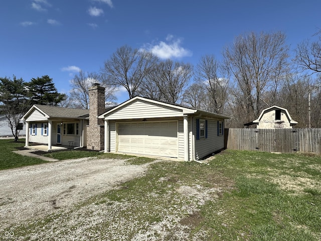 6672 E 225 S, Whitestown, IN 46075 - view of front of house with a front yard, a garage, a chimney, dirt driveway, and fence