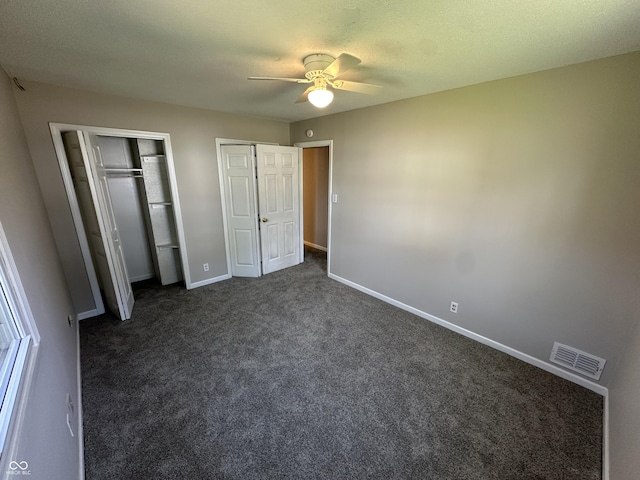 6672 E 225 S, Whitestown, IN 46075 - unfurnished bedroom with dark carpet, a textured ceiling, visible vents, multiple closets, and baseboards
