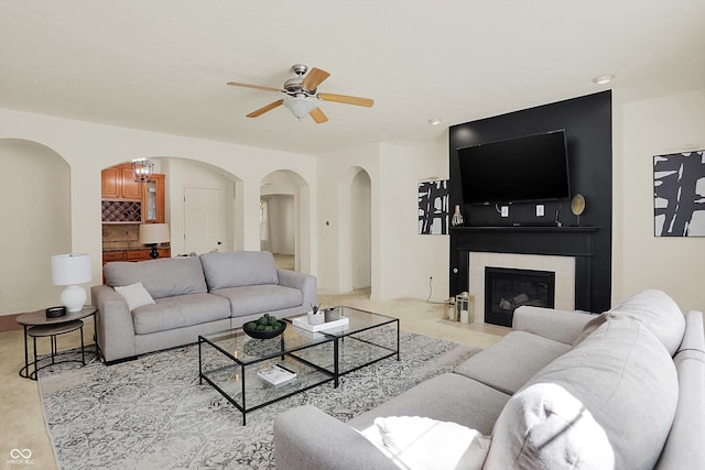 6869 W Winding, Mccordsville, IN 46055 - living room with ceiling fan, arched walkways, light carpet, and a fireplace with flush hearth