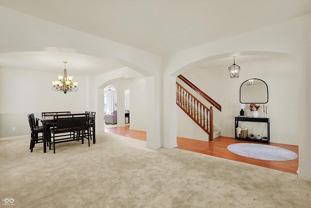 6869 W Winding, Mccordsville, IN 46055 - carpeted dining area with baseboards, stairway, arched walkways, and an inviting chandelier
