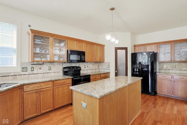 6869 W Winding, Mccordsville, IN 46055 - kitchen featuring tasteful backsplash, a center island, light stone countertops, light wood finished floors, and black appliances