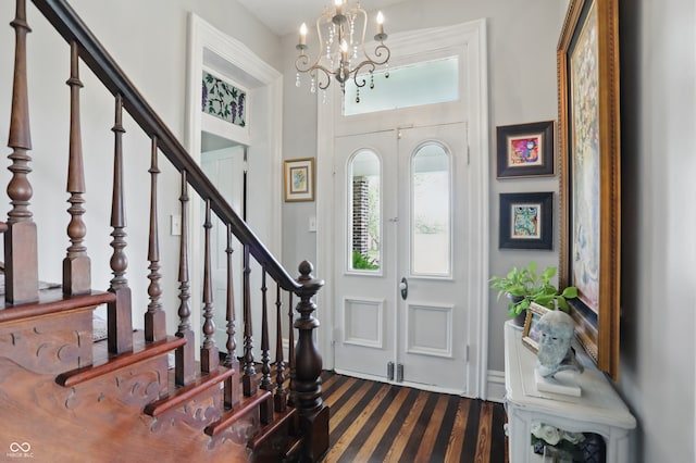 carpeted foyer entrance featuring a chandelier, a towering ceiling, and stairs