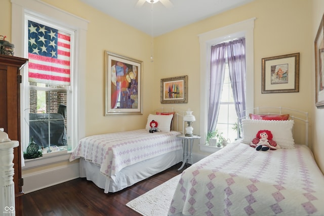 bedroom with dark wood finished floors, baseboards, and ceiling fan