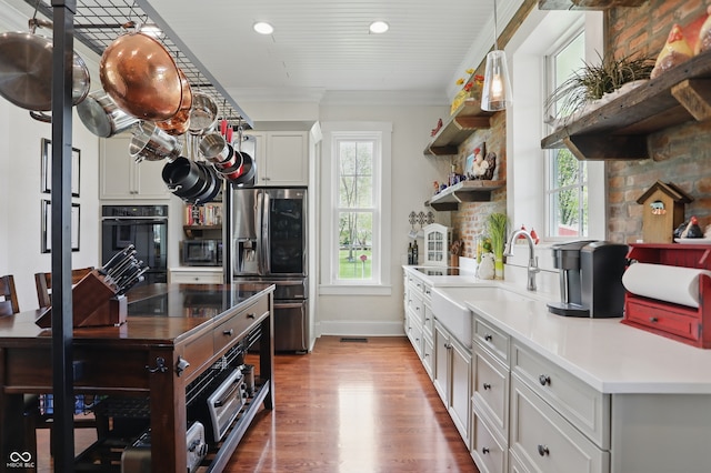 kitchen with wood finished floors, a sink, open shelves, black oven, and stainless steel fridge with ice dispenser