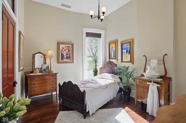 bedroom with a chandelier, visible vents, and dark wood-style flooring