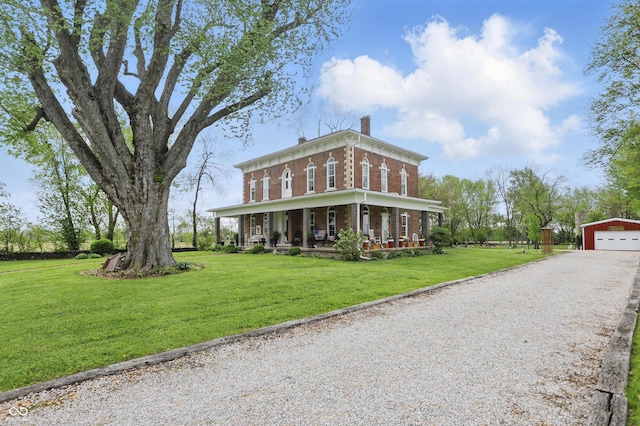 italianate home featuring a porch, a detached garage, brick siding, a front lawn, and a chimney